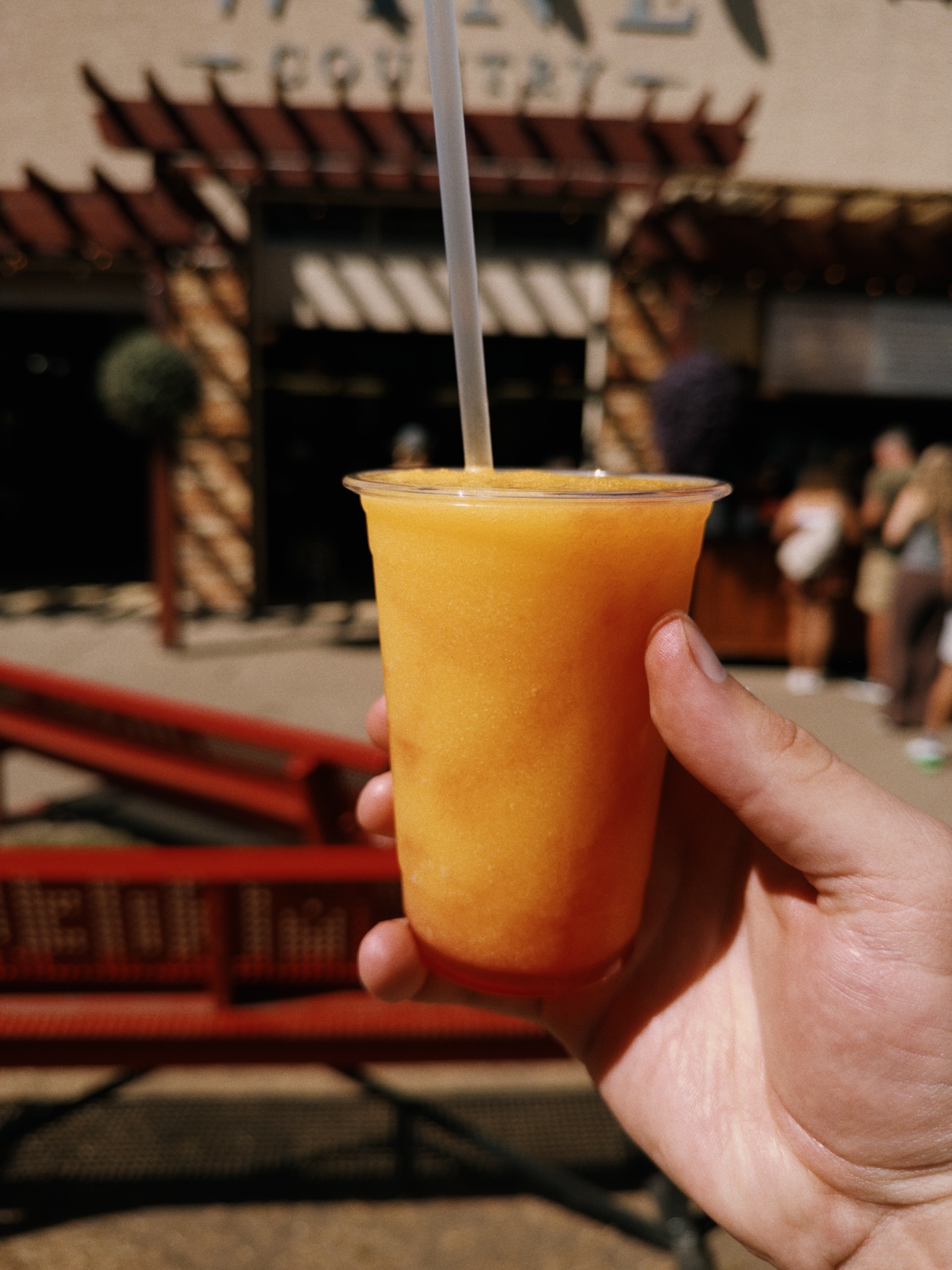 Bright orange frozen drink in a clear plastic cup