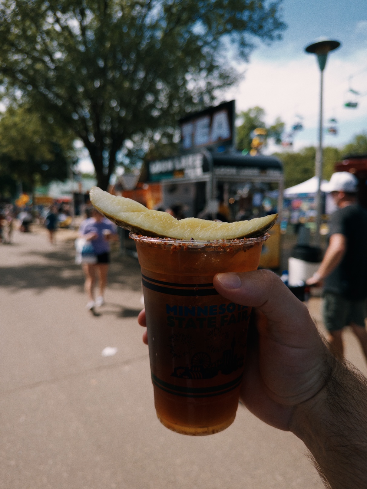 Amber iced tea with a seasoned rim and pickle spear