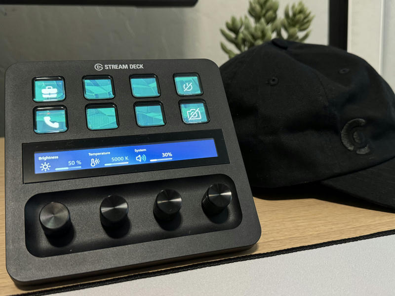 Close up photo of the Elgato Stream Deck +. To the right is a black hat with a black Clerk logo.
